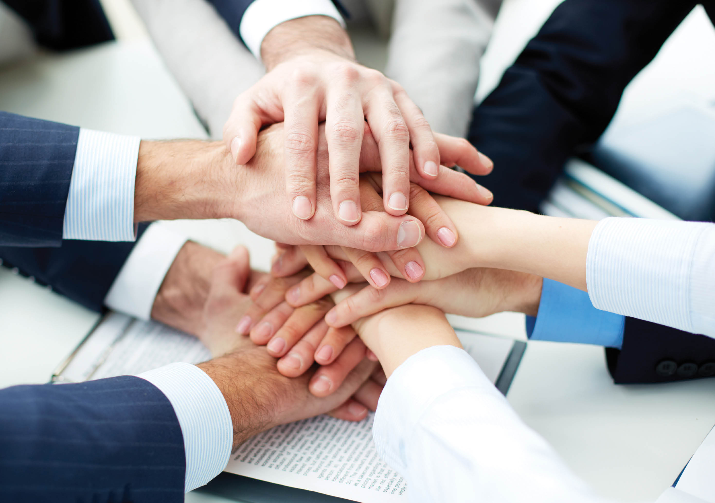 Close-up of business partners making pile of hands at meeting