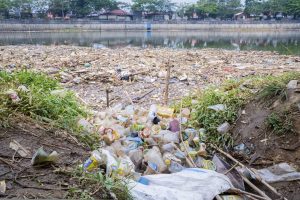 Various garbage floating on the polluted river